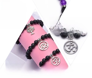 Detail of volcanic lava stone bracelet with tree of life and lotus flower charms