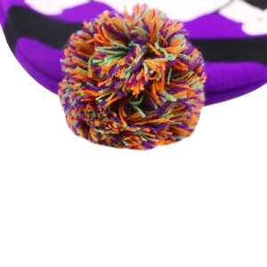 Macro shot of fluffy multicolor knit pom-pom in purple, orange, green and black yarn