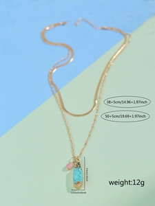 Detailed view of layered gold necklace with pendant size 3.4x1.1cm and 12g weight specs