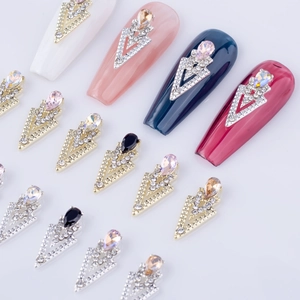 Macro detail of V-shaped alloy nail charms with colorful teardrop stones and rhinestones
