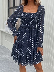 Blue polka dot mini dress with square neckline and ruffled hem on a model outdoors