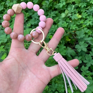 Close-up of pink silicone and marble beads bracelet with leather tassel on wrist