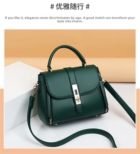Detail of dark green leather handbag featuring golden metal buckle and side zipper accents