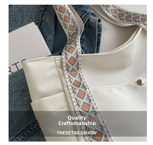 Dettaglio borsa tote bianca in nylon con tracolla intrecciata colorata e tasca laterale