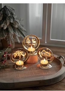 Detailed view of three golden Christmas candle holders with festive silhouettes on wood