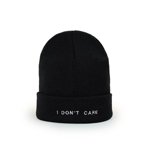 Detail of black knitted beanie with white I DON'T CARE embroidery on the folded cuff
