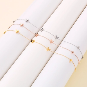 Three minimalist V-shaped pendants in gold, rose gold and silver on geometric cylinders