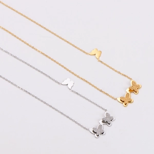 Detail shot of gold and silver butterfly necklaces with frosted finish and glitter details
