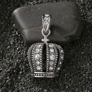 Macro view of vintage silver crown pendant with clear rhinestones on dark stones