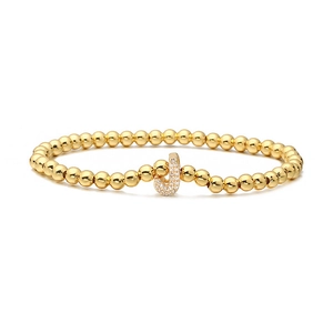 Detail shot of a gold-plated beaded stretch bracelet with a micro-paved zircon letter J charm