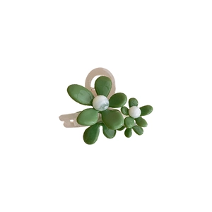 Pinza per capelli in acrilico verde con doppi fiori in resina e perle su sfondo bianco
