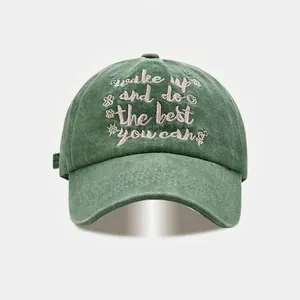 Vintage dark green washed cotton baseball cap with pink embroidered text and flower motifs