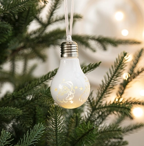 White Christmas bulb ornament with golden Santa Claus and star cutouts on a tree branch
