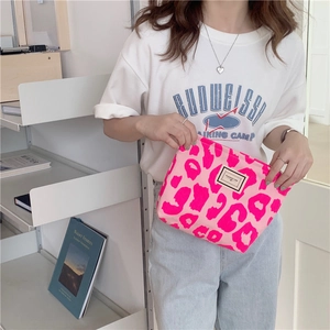 Close-up of pink leopard print canvas makeup bag with Pleasant Time logo and zipper