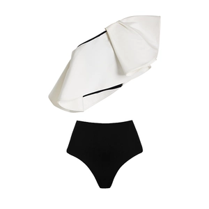 Detail of white one-shoulder ruffle top and high-waisted black bikini with textured fabric