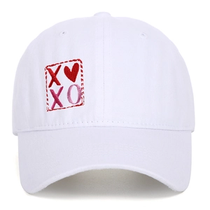 Dettaglio del ricamo XOXO e cuore su cappellino da baseball bianco in cotone lavato