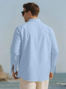 Detail of light blue linen shirt back showing loose fit and fabric drape in outdoor setting