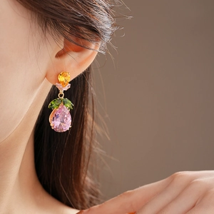 Detail of leaf design earrings with multi-color teardrop gemstones in gold plating
