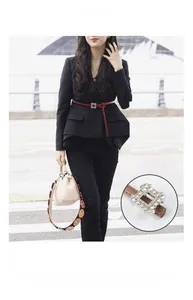 Detail of red thin leather belt with rhinestone buckle styled on a black blazer jacket