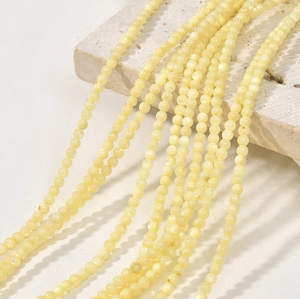 Macro detail of 3mm natural yellow shell beads strands for DIY jewelry making