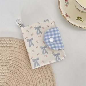 Detail of floral canvas card holder with blue gingham flap and white resin snap button
