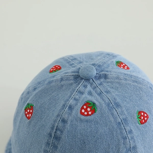 Light blue denim bucket hat for baby girls featuring cute strawberry embroidery and washed texture