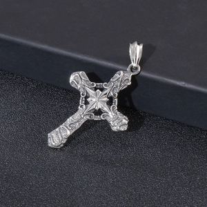 Detailed macro view of vintage gothic cross pendant with intricate filigree texture