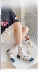 Gros plan de chaussettes blanches avec motifs floraux roses et accents bleus texturés