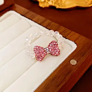 Sparkling pink rhinestone bow beaded ring on white velvet jewelry display box