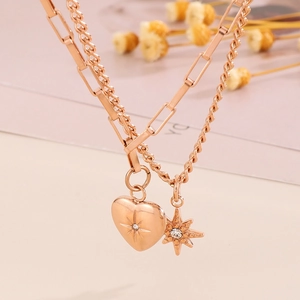 Detail of rose gold layered necklace featuring a heart and star pendant with crystal