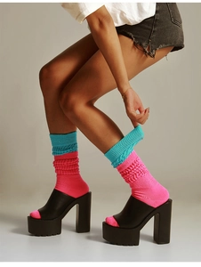 Close-up of pink and blue knitted slouch socks paired with black platform heels