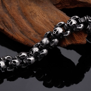 Macro shot of punk style stainless steel skull bracelet links on a wood block
