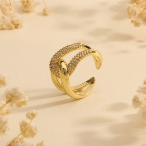 Close-up of a double-layered 18K gold-plated ring with zircon accents on beige background