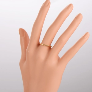 Detail of minimalist gold textured ring with hammer finish on a hand model