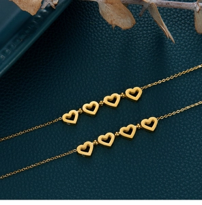 Détail du collier trèfle pliable avec pendentifs cœurs en acier plaqué or 18 carats