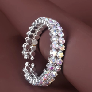 Macro shot of silver-tone bracelet with sparkling colorful rhinestones on a curved surface