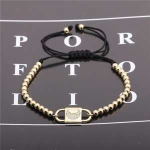 Detail of adjustable black cord bracelet with gold beads and zircon moon lock pendant