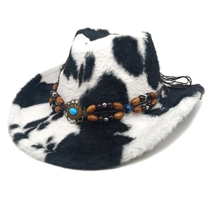 Détail du chapeau de cowboy à motif vache avec pierre turquoise et perles en bois
