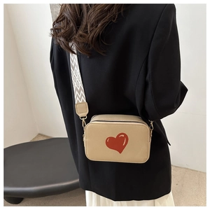 Detail of khaki square crossbody bag with red heart print and geometric wide strap