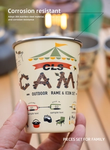 Close-up of hand holding a cream stainless steel camping cup with outdoor scenery