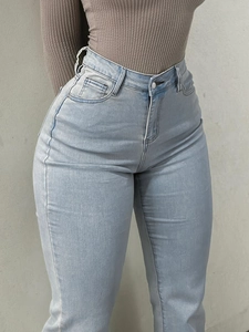 Detail of high waisted light blue slim fit flared jeans with premium denim texture