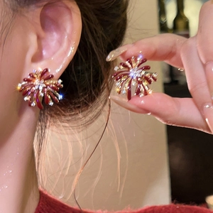 Macro detail of vintage red enamel flower earrings with gold finish and sparkling zircons