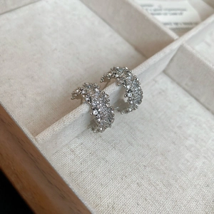 Vue détaillée de boucles d'oreilles argentées en C ornées de pavé de zircons brillants