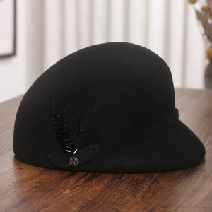 Detailed close-up of a black wool felt hat with floral applique and rose metal button