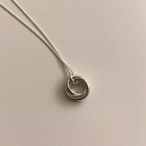 Detail of three interlocking silver circles pendant on a minimalist 925 silver necklace