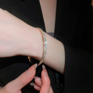 Close-up of rose gold pave-set crystal bangle on wrist with elegant sparkling finish