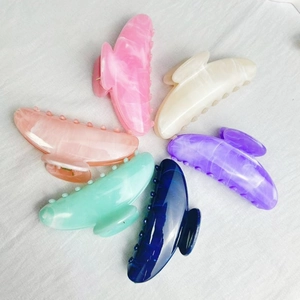 Ink painted marble pattern hair claws in six vibrant colors on white fabric background