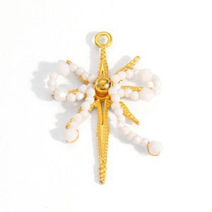 Close-up of 18k gold-plated cross star pendant featuring elegant white pearl bow detailing