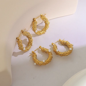 Créoles dorées vintage martelées avec perles et texture lave sur support géométrique