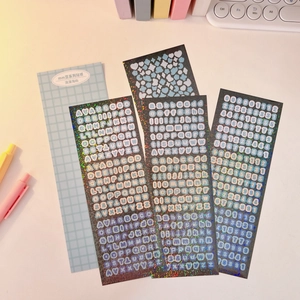 Detail of four holographic laser stickers with letters and numbers for scrapbooking decor